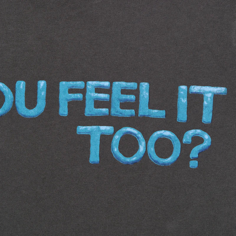 Close-up of the “DO YOU FEEL IT TOO?” text on Billie Eilish’s crop t-shirt, showing off the textured blue bubble-style font on soft black cotton. A detailed look at the standout feature of this expressive merch piece.