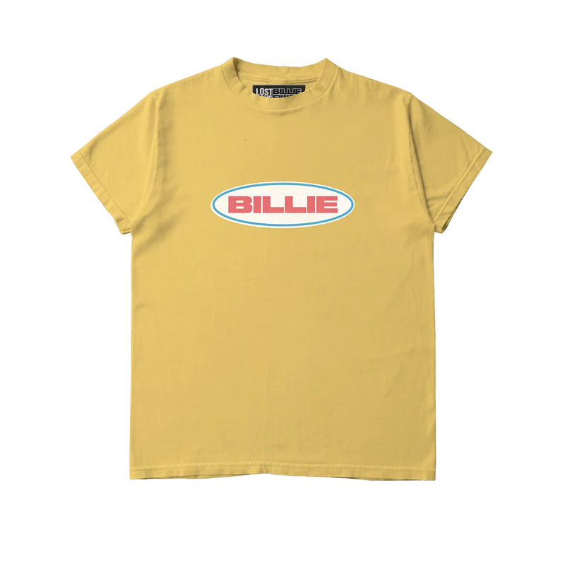 Mustard yellow Billie Eilish x Lost Love T-shirt featuring a bold retro-style "BILLIE" logo in red text inside a white oval with teal outline. Eye-catching sustainable merch tee made from reworked materials with a vintage vibe.