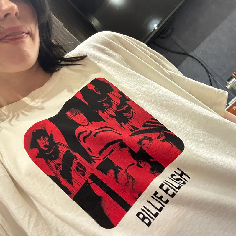 Close-up side view of Billie Eilish wearing the Thermal BE Collage Photo Tee, featuring a red-and-black collage graphic of her past styles with “BILLIE EILISH” text underneath. Soft cream T-shirt blending nostalgic visuals and iconic artist branding.