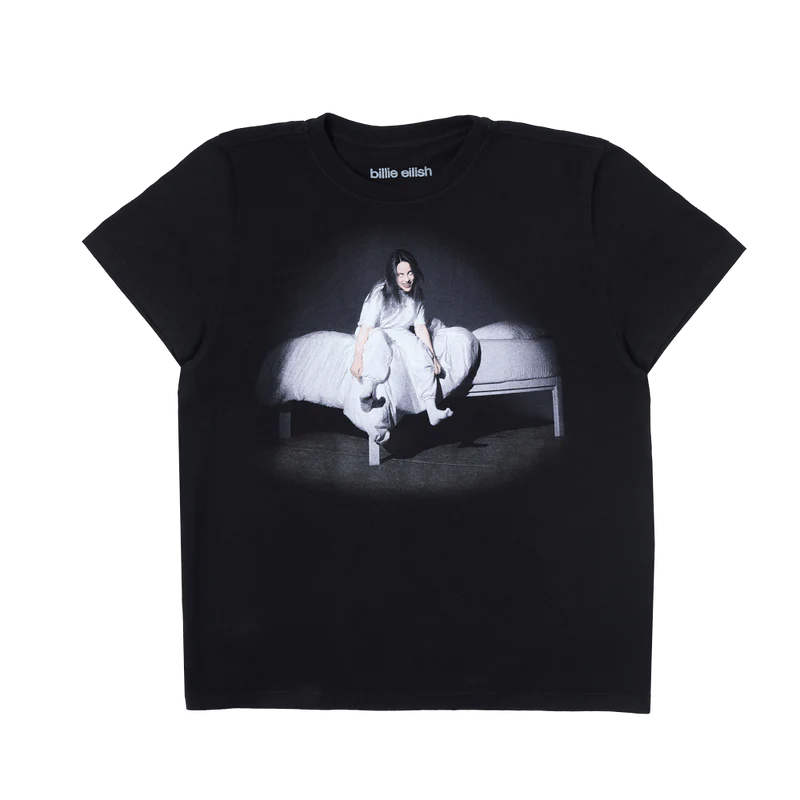 Black Billie Eilish anniversary t-shirt featuring the haunting WHEN WE ALL FALL ASLEEP, WHERE DO WE GO? album cover—Billie sitting on the edge of a white bed with glowing eyes and eerie expression. A fan-favorite graphic from her iconic debut era.