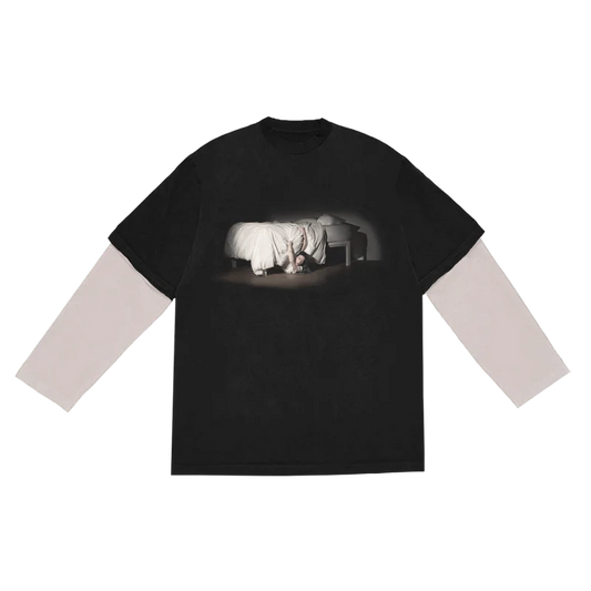 Front view of Billie Eilish's “WHEN WE ALL FALL ASLEEP, WHERE DO WE GO?” anniversary long sleeve tee in black, featuring a haunting photo of Billie crawling out from under a bed, with layered white sleeves. A standout piece from Billie Eilish’s official anniversary merch celebrating her debut album.

